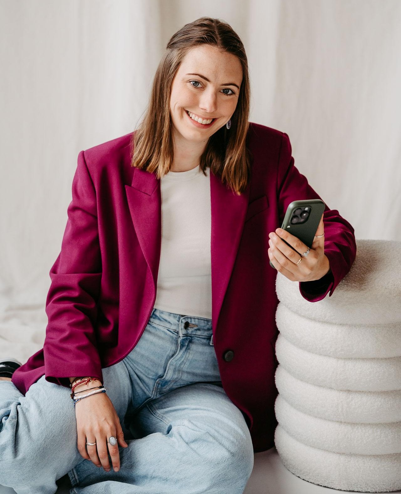 Foto von Anna mit Smartphone - sie wirkt total motiviert und glücklich.