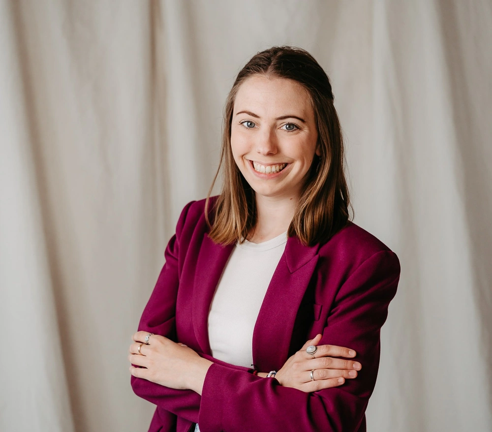 Anna Proprentner lächelt selbstbewusst in die Kamera. Anna ist dein Business Buddy auf Augenhöhe, wenn es darum geht, dein Business voran zu bringen.