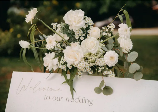 Willkommensschild bei einer Hochzeit mit Blumenschmuck